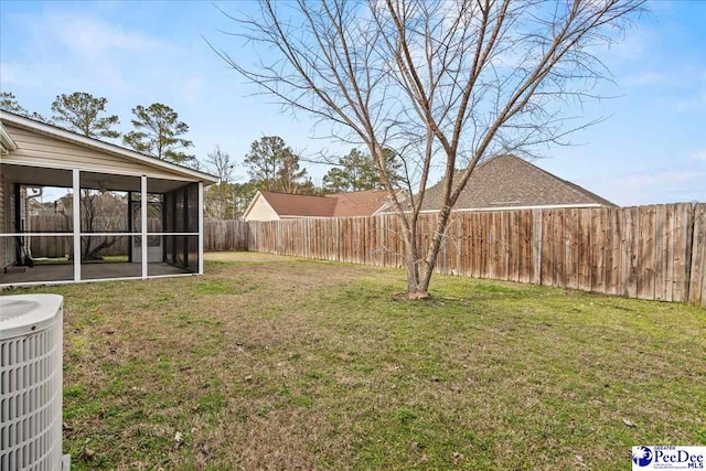 view of yard with central AC unit, a fenced backyard, and a sunroom