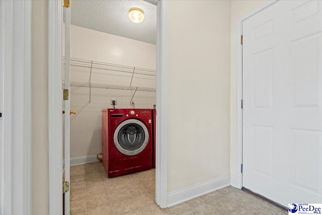 laundry area with laundry area, baseboards, washer / clothes dryer, and a textured ceiling