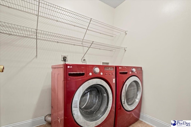 clothes washing area with washer and dryer, laundry area, and baseboards