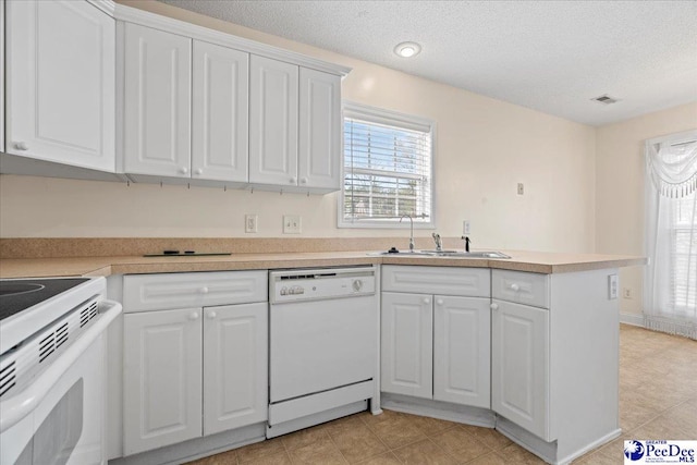 kitchen with white appliances, a peninsula, light countertops, white cabinetry, and a sink