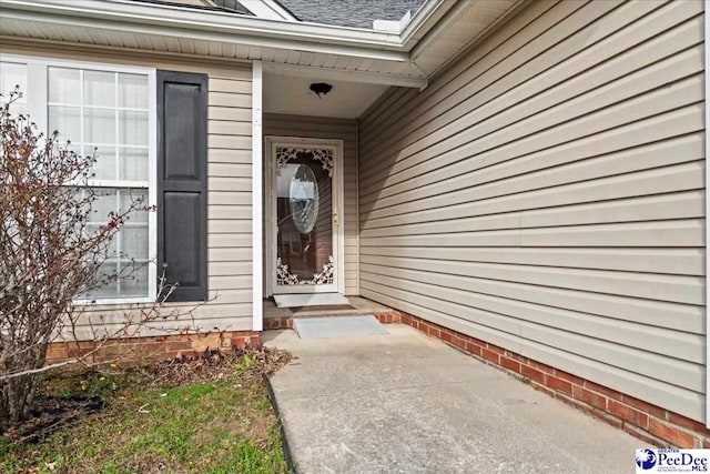 doorway to property featuring a shingled roof