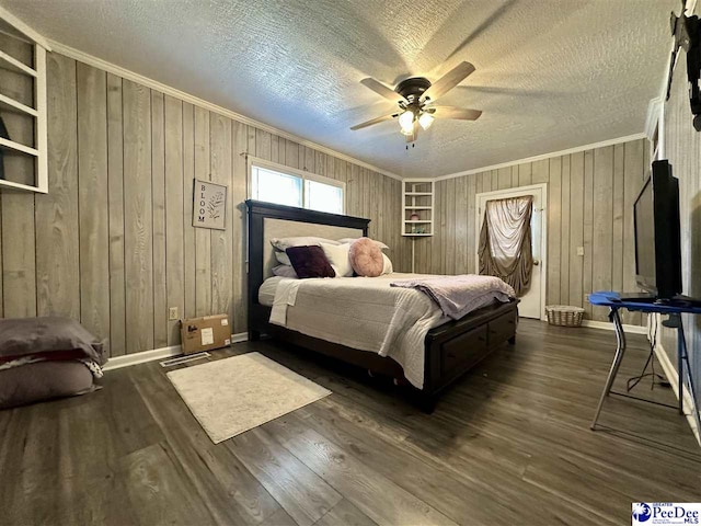 bedroom with crown molding, ceiling fan, dark hardwood / wood-style floors, a textured ceiling, and wood walls