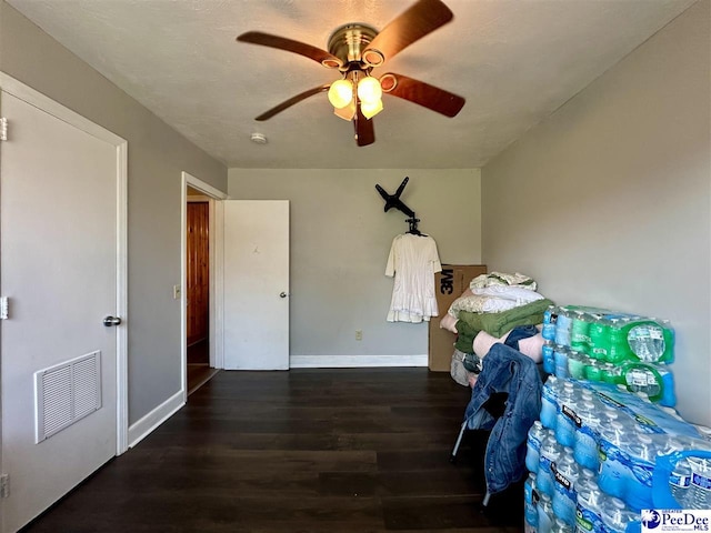 bedroom with dark hardwood / wood-style flooring and ceiling fan