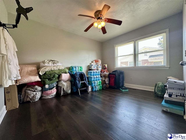 misc room featuring ceiling fan, dark hardwood / wood-style floors, and a textured ceiling