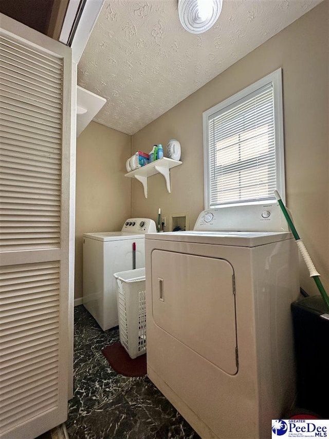 laundry area featuring washing machine and dryer and a textured ceiling