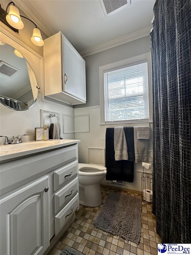 bathroom featuring vanity, crown molding, and toilet