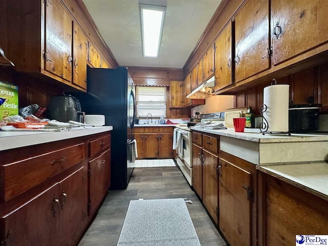 kitchen featuring black refrigerator, white electric range, dark hardwood / wood-style floors, and sink