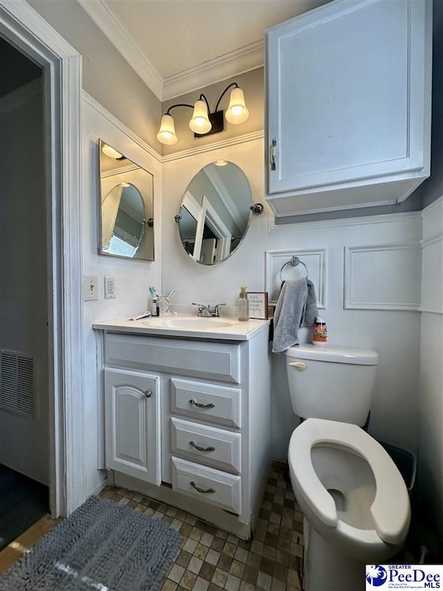 bathroom featuring crown molding, vanity, and toilet