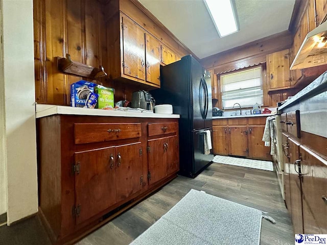 kitchen featuring sink, dark wood-type flooring, and black fridge