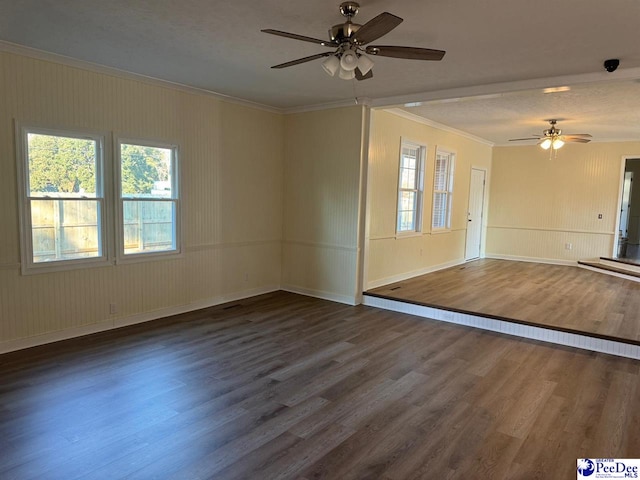 unfurnished living room featuring ceiling fan, a healthy amount of sunlight, ornamental molding, and dark hardwood / wood-style flooring