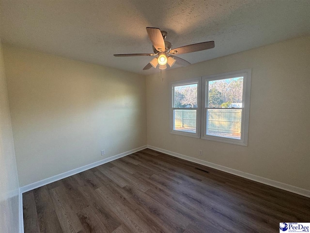 spare room with dark wood-type flooring, ceiling fan, and a textured ceiling