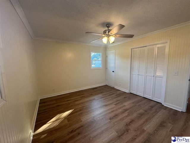 unfurnished bedroom with dark hardwood / wood-style flooring, crown molding, and a textured ceiling