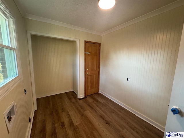 unfurnished bedroom with crown molding, dark wood-type flooring, a closet, and a textured ceiling