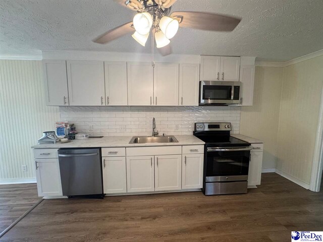 kitchen featuring appliances with stainless steel finishes, sink, white cabinets, and dark hardwood / wood-style flooring