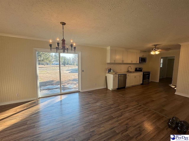 kitchen featuring sink, appliances with stainless steel finishes, dark hardwood / wood-style floors, white cabinets, and decorative light fixtures