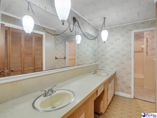 1709 N Irby St, Florence, SC 29501 - bathroom featuring double vanity, a tile shower, ornamental molding, wallpapered walls, and baseboards