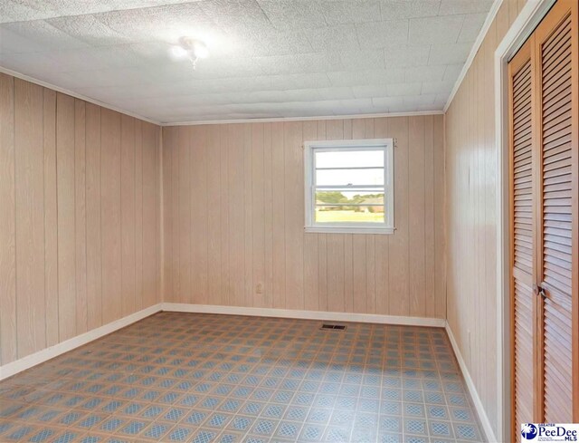 1709 N Irby St, Florence, SC 29501 - unfurnished bedroom with tile patterned floors, baseboards, a closet, and wood walls