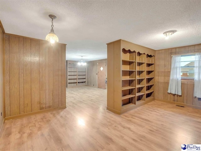 1709 N Irby St, Florence, SC 29501 - unfurnished room featuring wooden walls, wood finished floors, a chandelier, baseboards, and a textured ceiling