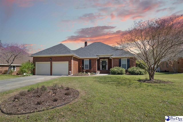 ranch-style home featuring brick siding, a lawn, driveway, and an attached garage