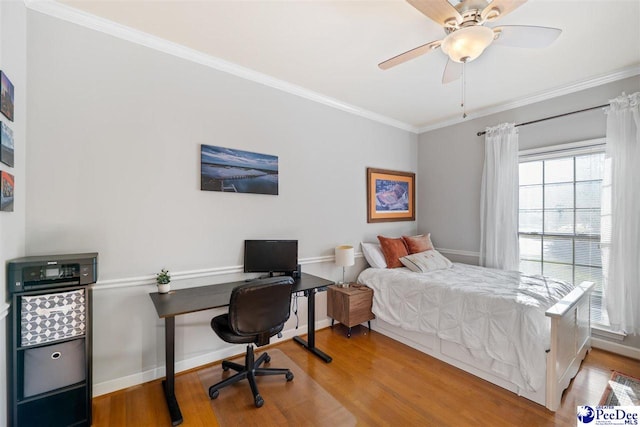 bedroom featuring baseboards, a ceiling fan, wood finished floors, and crown molding
