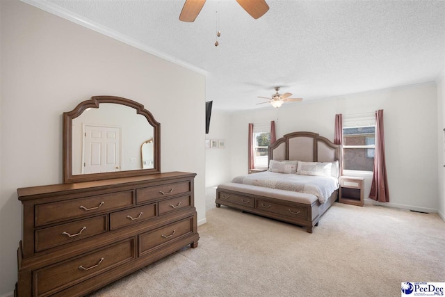 bedroom with a textured ceiling, a ceiling fan, crown molding, and light carpet