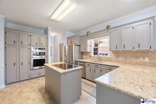 kitchen featuring a center island, a sink, decorative backsplash, and appliances with stainless steel finishes