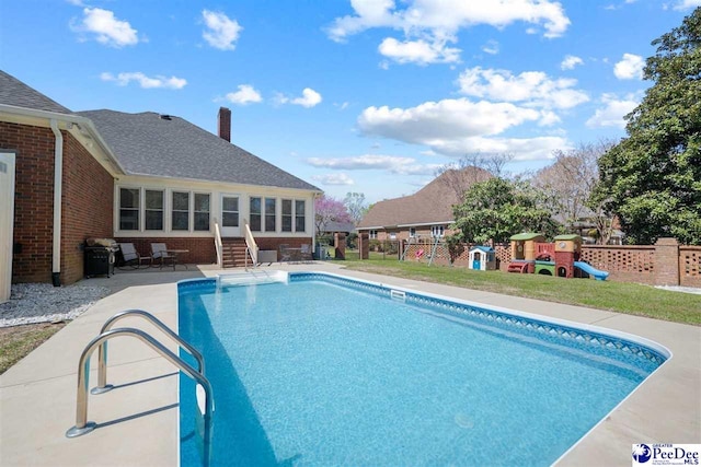 view of swimming pool featuring fence, a patio, entry steps, a fenced in pool, and a playground