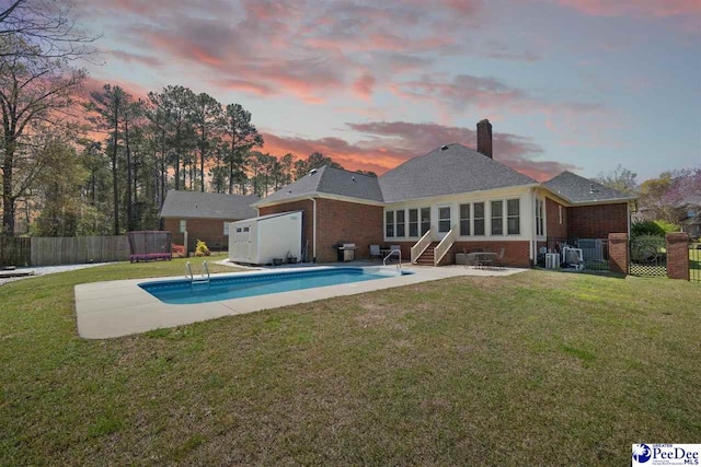 rear view of property featuring fence, entry steps, a patio area, and a yard
