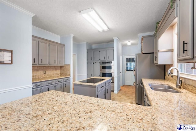 kitchen featuring black electric cooktop, a sink, gray cabinets, and double oven