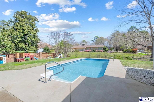 outdoor pool with a fenced backyard, a playground, a patio, and a yard