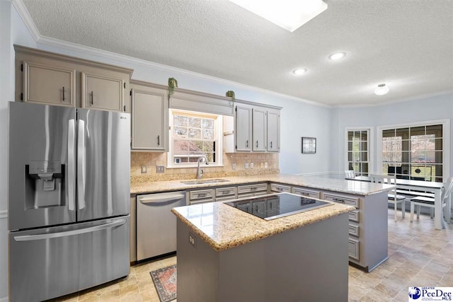 kitchen with a sink, appliances with stainless steel finishes, a peninsula, a center island, and decorative backsplash