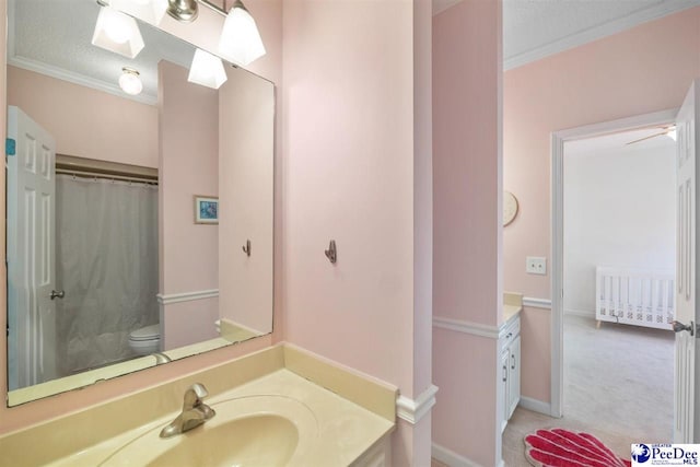 bathroom featuring ornamental molding, toilet, and vanity