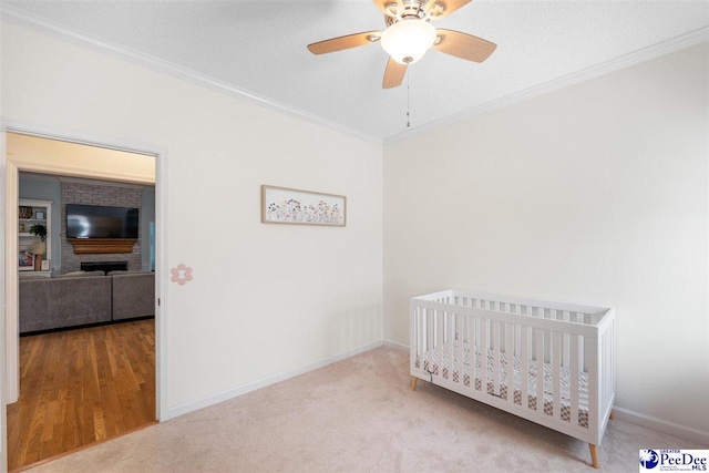 bedroom featuring baseboards, crown molding, and a crib