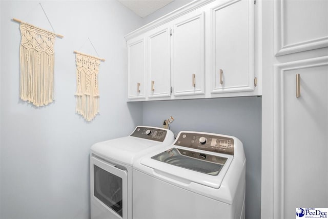 washroom with washer and clothes dryer and cabinet space
