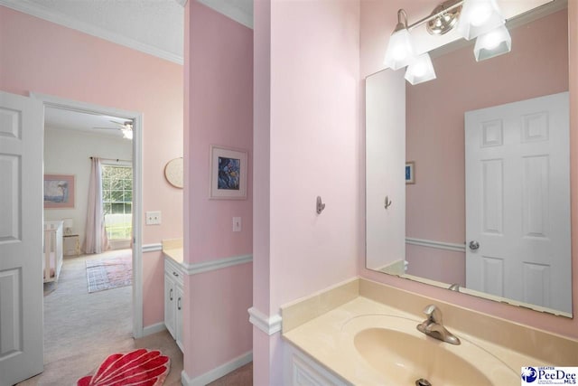 bathroom with baseboards, crown molding, and vanity