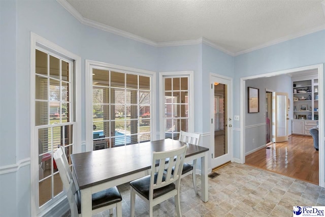 dining space featuring visible vents, crown molding, baseboards, and a textured ceiling