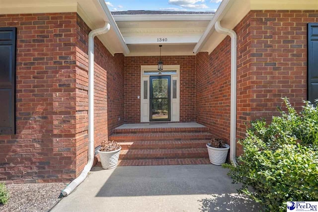 view of exterior entry with brick siding