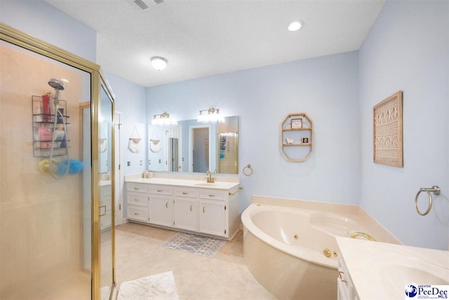 bathroom with a textured ceiling, a tub with jets, a shower stall, a sink, and two vanities