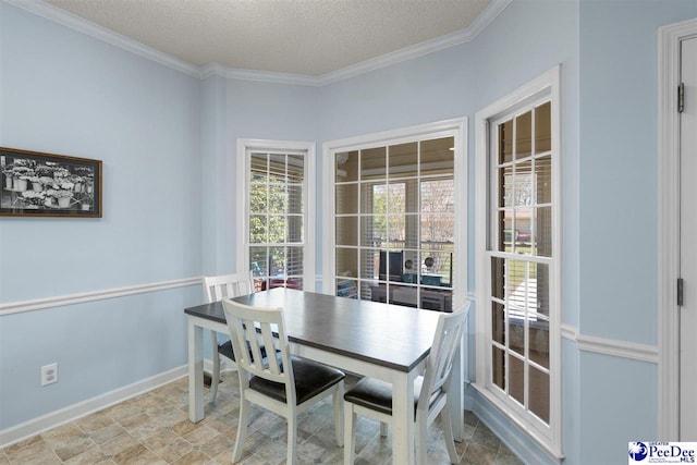 dining area featuring baseboards, a textured ceiling, and ornamental molding