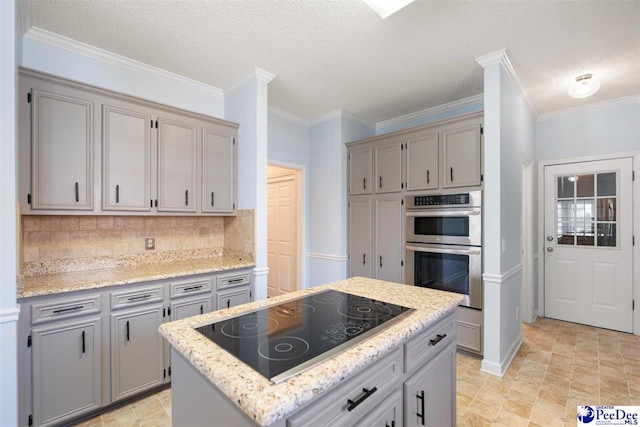 kitchen featuring black electric cooktop, gray cabinets, double oven, backsplash, and a kitchen island