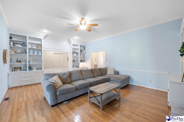 living room with ornamental molding, visible vents, light wood-style floors, and a ceiling fan