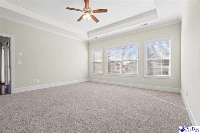 carpeted spare room with ornamental molding, a raised ceiling, and ceiling fan