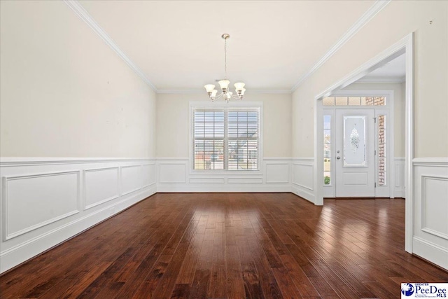 entryway with ornamental molding, dark hardwood / wood-style floors, and a notable chandelier