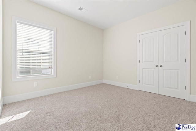 unfurnished bedroom with a closet and carpet flooring