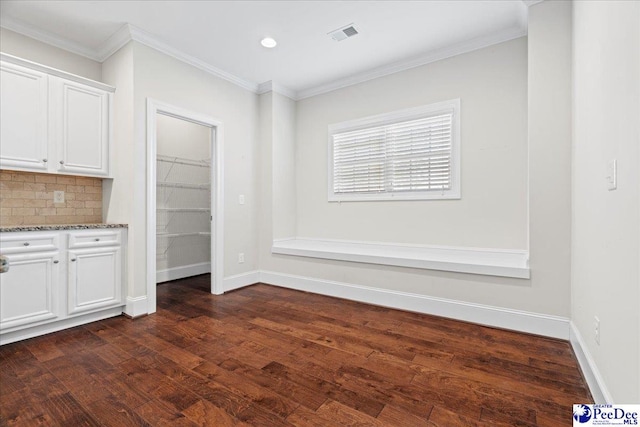 unfurnished dining area featuring crown molding and dark hardwood / wood-style floors