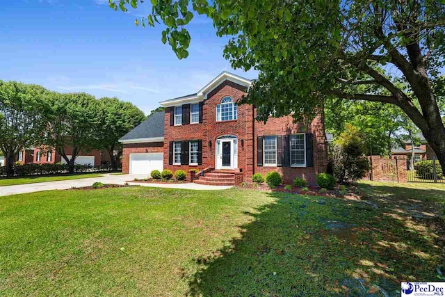 colonial home featuring concrete driveway, a front yard, brick siding, and an attached garage