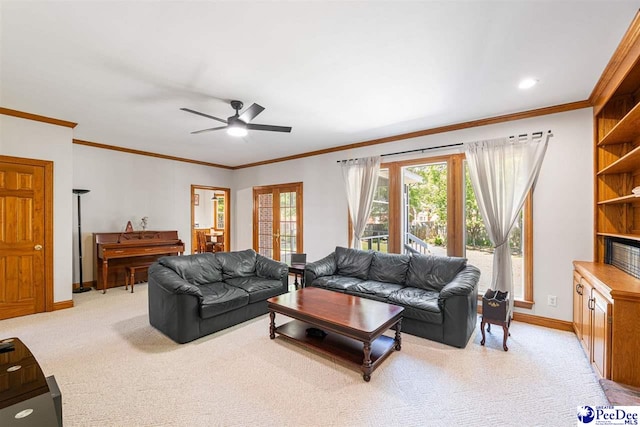 living area with ornamental molding, baseboards, and a ceiling fan