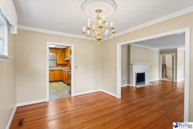 unfurnished living room featuring a fireplace with flush hearth, baseboards, light wood-style flooring, and a chandelier
