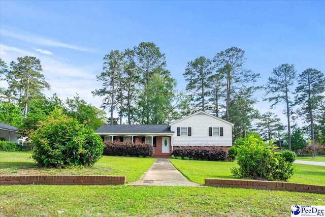 tri-level home featuring a front lawn and brick siding