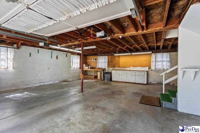 garage with concrete block wall and a garage door opener